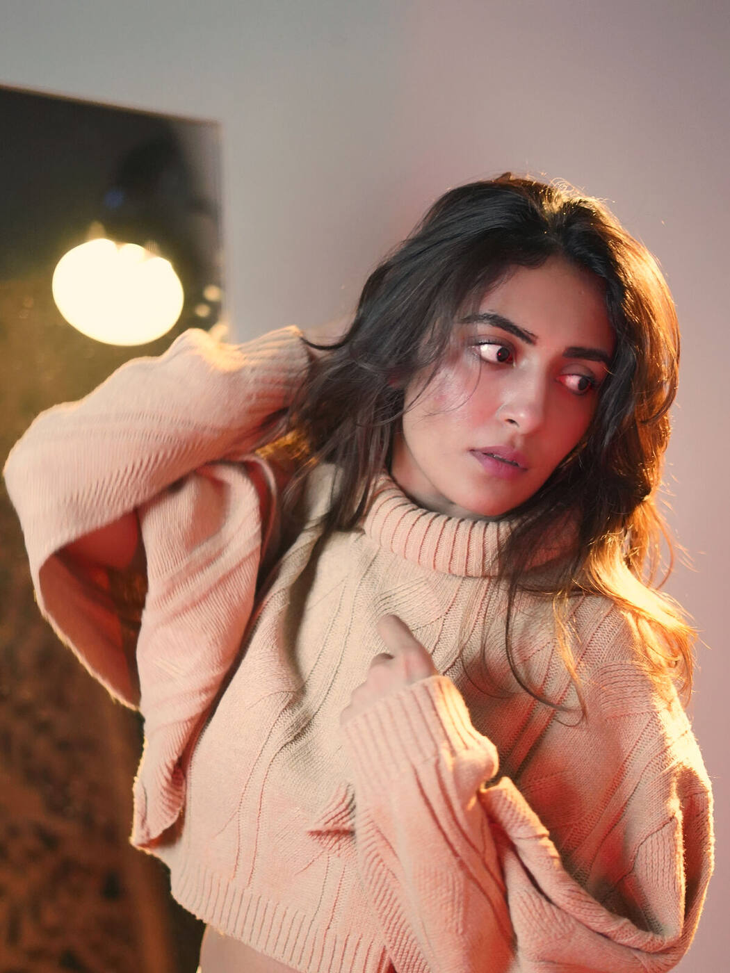 Jinal in a soft knit sweater, looking over her shoulder